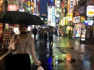 A woman holds an umbrella in the Kabukicho red-light district in June