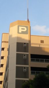 A woman sits atop a parking garage across from the Loft department store in Nagoya