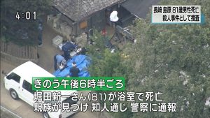 Investigators are seen working outside the home of Shinichi Hotta in Shimabara City