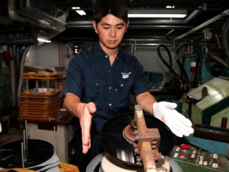 An employee at the Tokyo Kasei factory prepares a disc