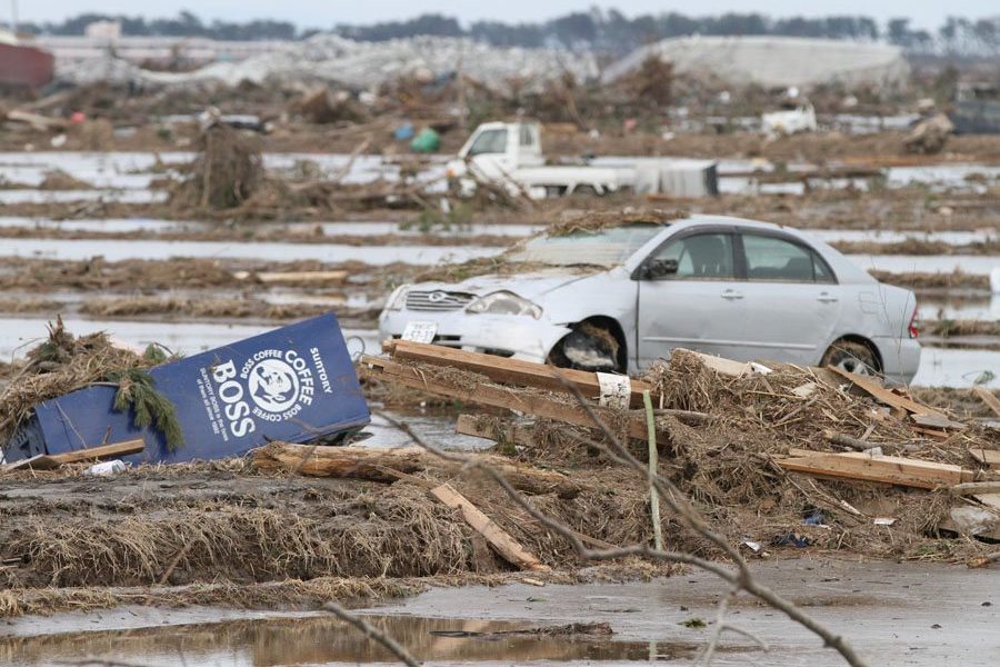 A vending machine moved by the tsunami sits in a field in Wakabayashi Ward