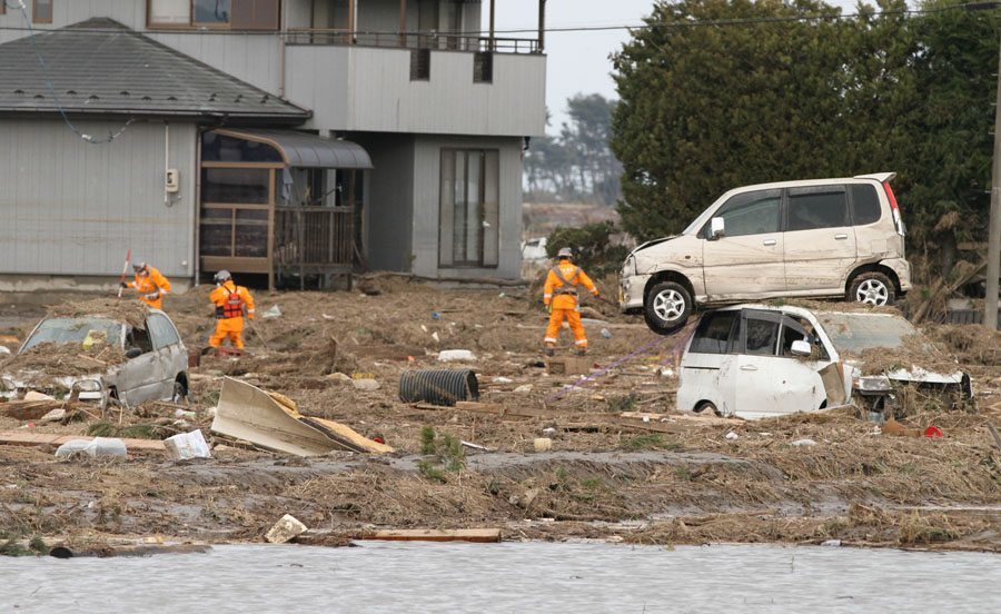 Rescue workers search a field in Wakabayashi Ward
