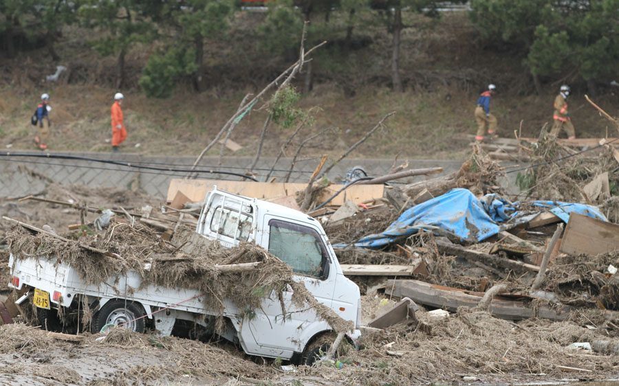 Rescue workers search a field in Wakabayashi Ward