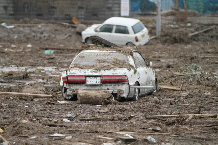 A car moved by the tsunami sits in a field in Wakabayashi Ward