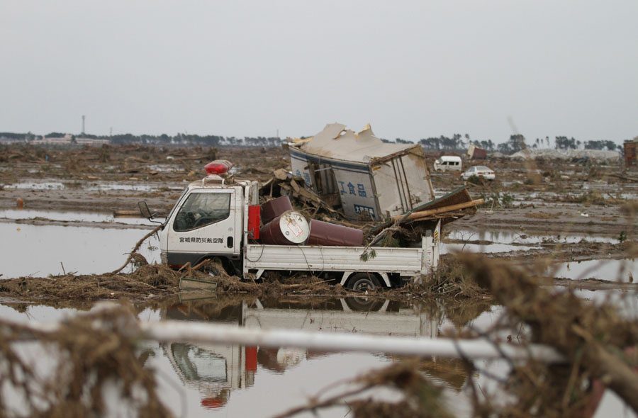 A truck moved by the tsunami sits in a field in Wakabayashi Ward