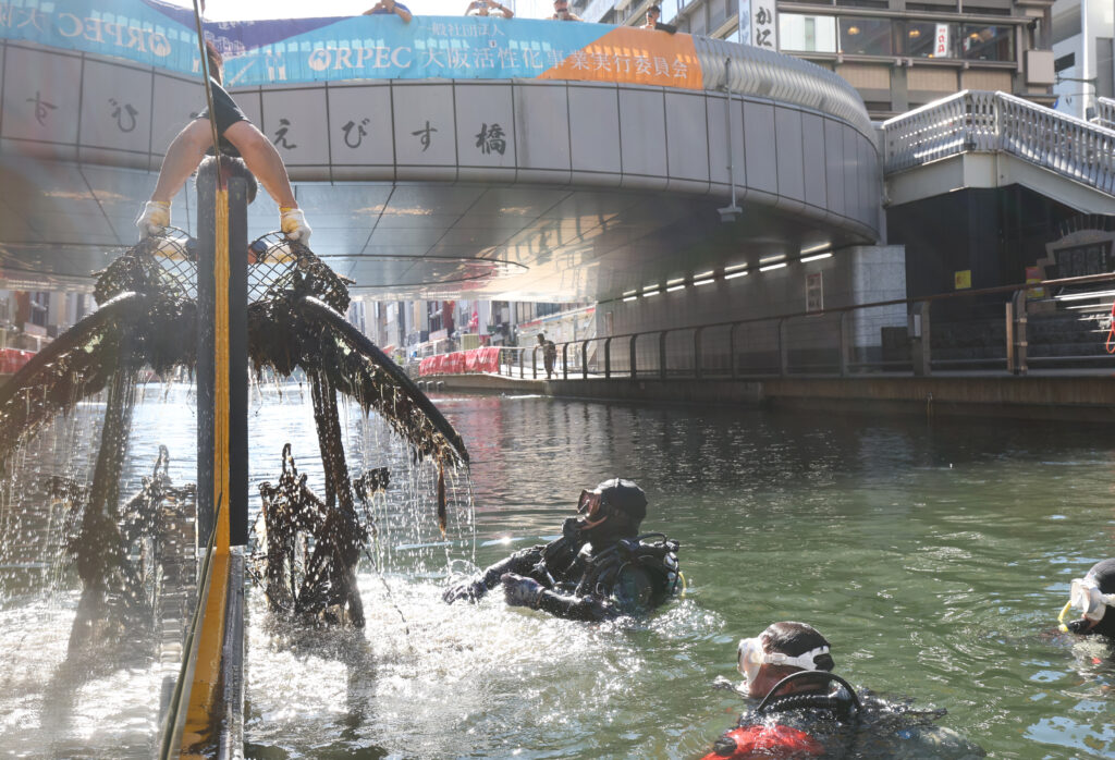 Divers haul sunken bicycles, wallets from murky depths of Osaka's Dotonbori River
