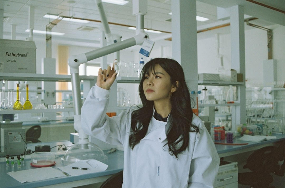 A scientist in a white coat analyzing a sample in a laboratory