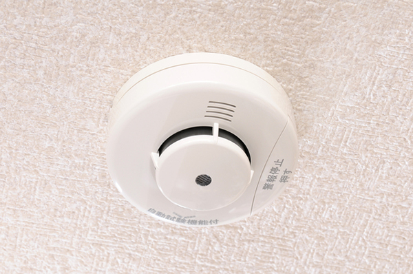 A man installed a camera behind a fire alarm