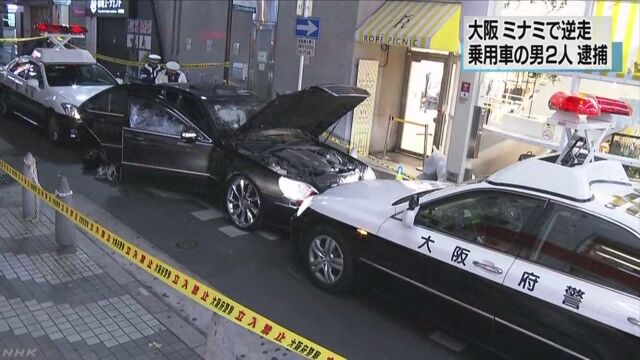 A male driver suddenly backed up when approached by an officer before smashing into a patrol car (NHK)
