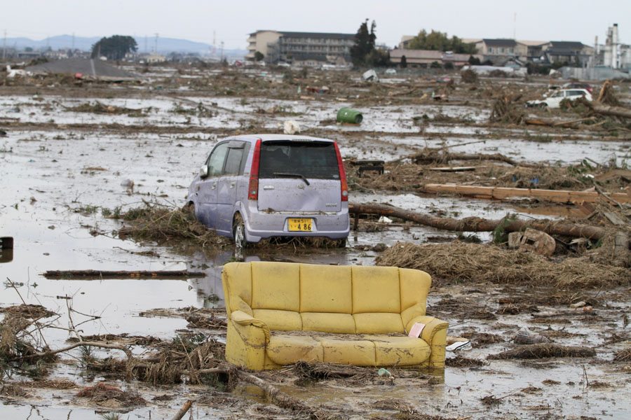 A sofa sits among cars tossed by the tsunami in Wakabayashi Ward, Sendai