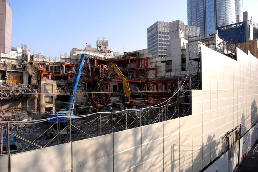 The TSK.CCC building is seen during demolition with Roppongi Hills at right