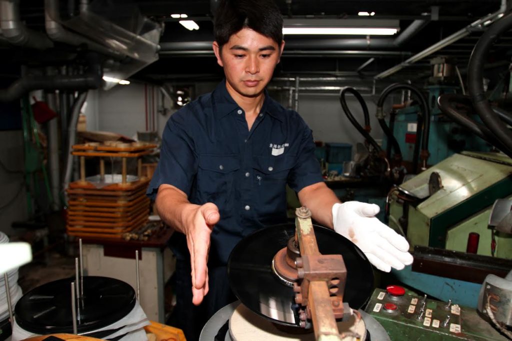 An employee at the Tokyo Kasei factory prepares a disc